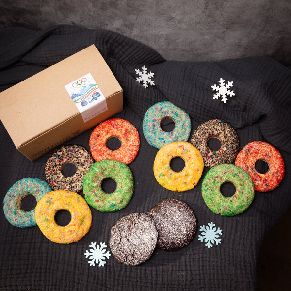Colorful ring-shaped cookies packaged in a box featuring Olympics design.