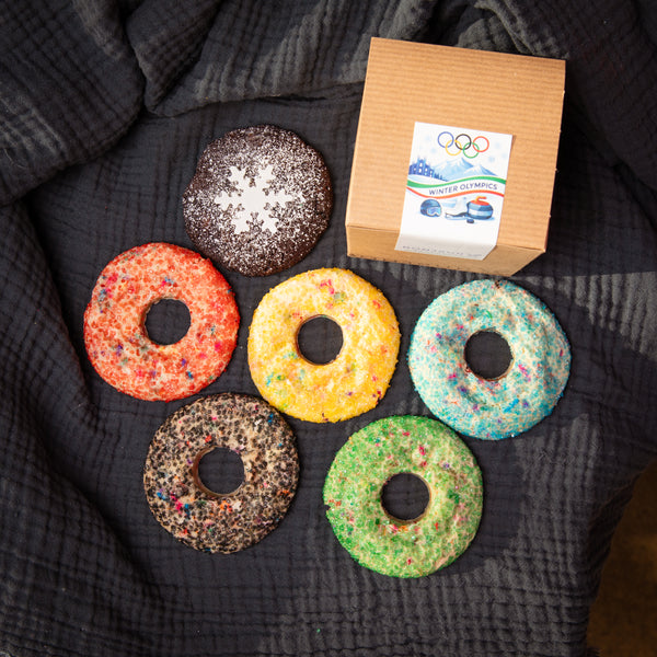 Colorful ring-shaped cookies with a box labeled 'Olympics'.